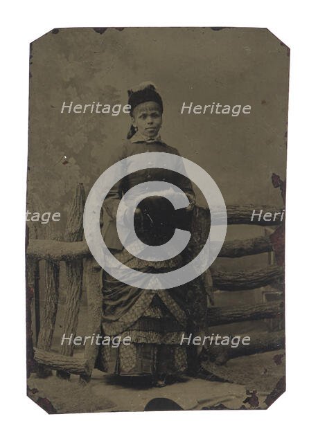 Tintype of woman in jacket and dress with hat and muff, 1880s. Creator: Unknown.