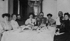 Fire Chief A. F. Domishkevich Sitting at a Table Set for a Holiday Together with..., early 20th cent Creator: Unknown.