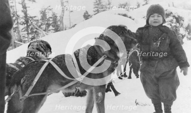 Child and dogs, between c1900 and c1930. Creator: Unknown.