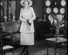 A Female Civilian Modelling a Two Piece Suit and Hat Posing in a Drawing Room, 1920. Creator: British Pathe Ltd.