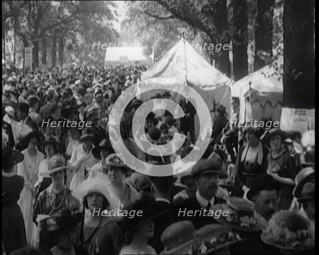People Gathering and Relaxing at a Fairground Between Marquees and Balloons, 1920. Creator: British Pathe Ltd.