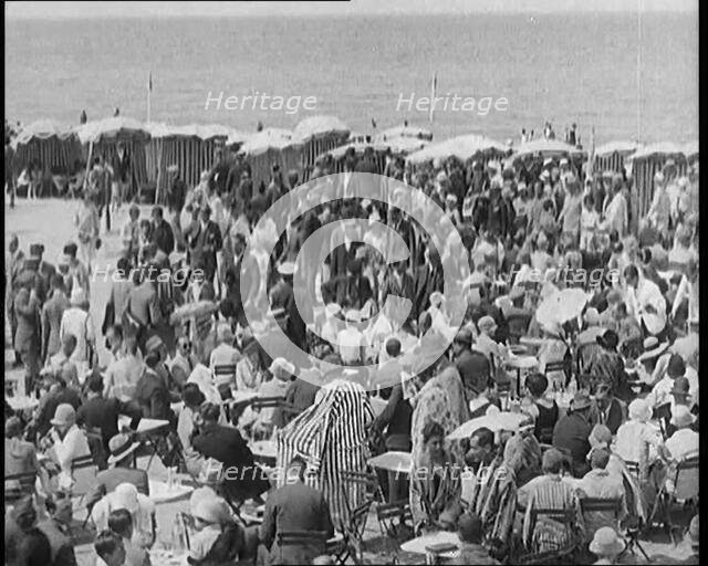 Civilians Enjoying a Sunny day on a Very Crowded Beach, 1920. Creator: British Pathe Ltd.