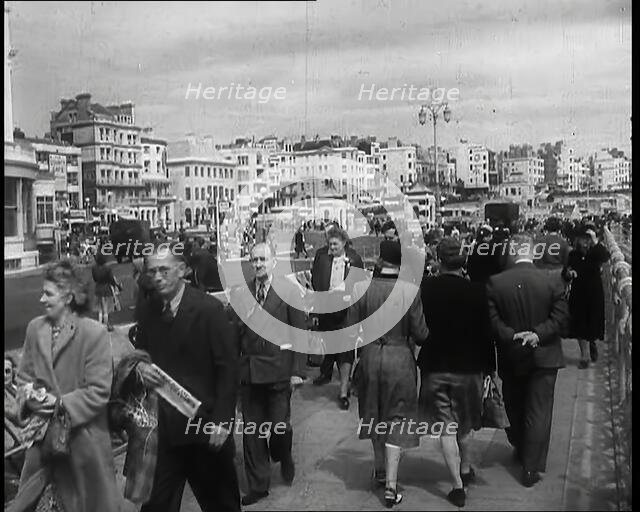 A Cloudy Day as Male and Female Pedestrians are Walking on the Promenade at  Brighton..., 1939. Creator: British Pathe Ltd.