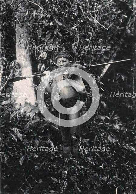 Sarawak: a Kenyah hunter with blowpipe and dead animal, c1900. Creator: Unknown.