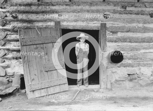 North Carolina farm boy in doorway of tobacco barn, Person County, North Carolina, 1939. Creator: Dorothea Lange.