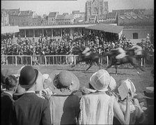 A Large Crowd of Civilians Wearing Smart Outfits and Hats Watching a Horse Race, 1920. Creator: British Pathe Ltd.