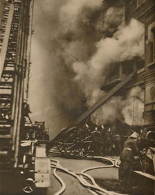 'Subduing a Conflagration in a Narrow City Street', c1935. Creator: Unknown.