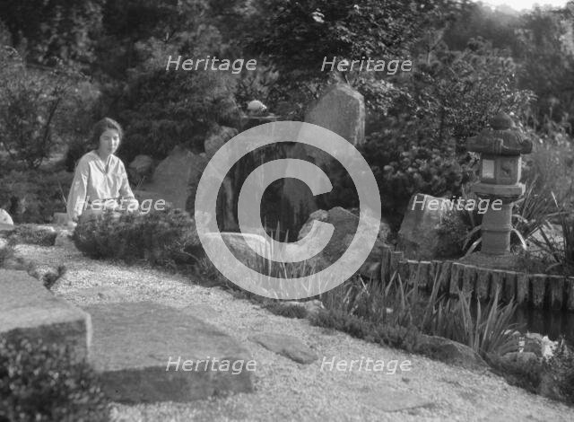 Unidentified woman seated in a garden next to a stream, possibly belonging to A.W. Bahr, c 1917-1934 Creator: Arnold Genthe.