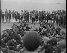 A Group of Female Civilians Exercising with a Large Ball on a Beach, 1920. Creator: British Pathe Ltd.