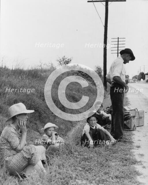 A hitchhiking family waiting along the highway in Macon, Georgia, 1937. Creator: Dorothea Lange.