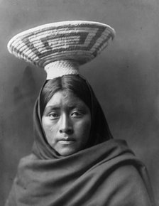 Papago Indian, Luzi, head-and-shoulders portrait, facing front, with a basket tray on her head,c1907 Creator: Edward Sheriff Curtis.