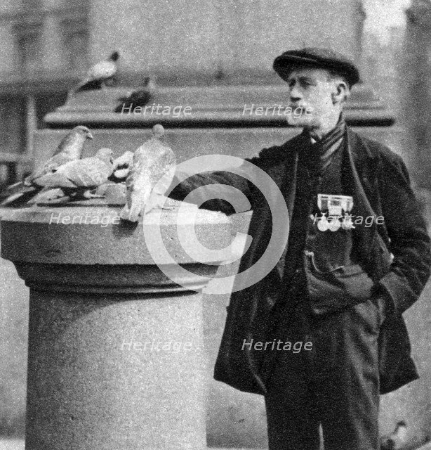 An old soldier with some pigeons, Trafalgar Square, London, 1926-1927.Artist: McLeish