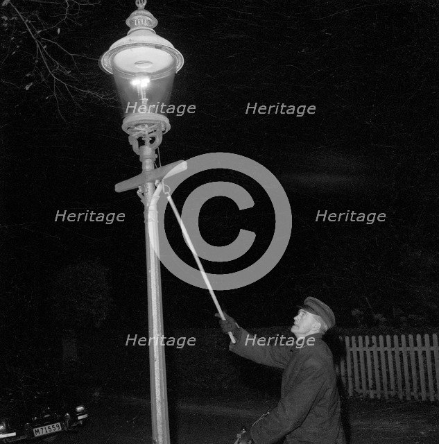 Lighting a gas lantern. Landskrona, Sweden, 1956. Artist: Unknown