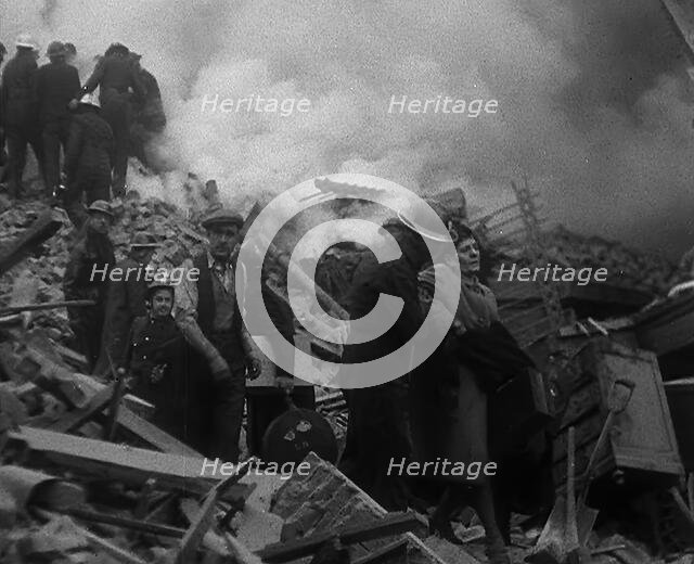 Firefighters Helping an Injured Civilian During the Blitz, 1940. Creator: British Pathe Ltd.