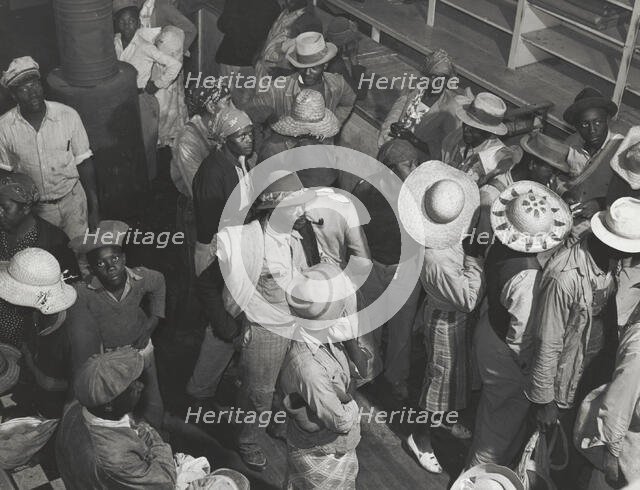 Negro day laborers brought in by truck from nearby towns, waiting to be paid off and..., Oct 1939. Creators: Farm Security Administration, Marion Post Wolcott.