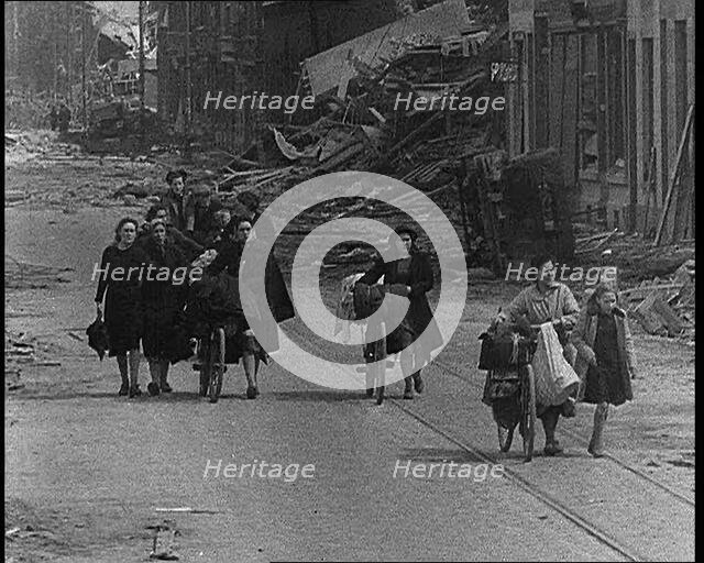 Belgian Refugees Fleeing Their Town Along Bomb Damaged Road, 1940. Creator: British Pathe Ltd.