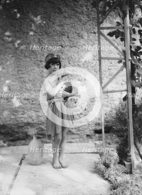 Kanellos child in dance costume holding a cat, 1929 Creator: Arnold Genthe.