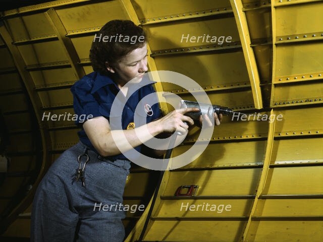 Operating a hand drill at Vultee-Nashville, woman is working on a "Vengeance" dive..., Tenn., 1943. Creator: Alfred T Palmer.