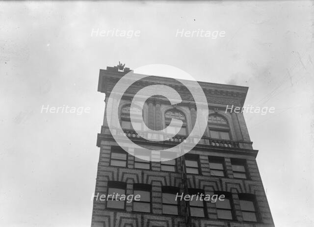 J. Reynolds, Performing Acrobatic And Balancing Acts On High Cornice Above 9th Street, N.W., 1917. Creator: Harris & Ewing.
