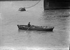 A man rowing a boat in London docks, c1945-c1965. Artist: SW Rawlings