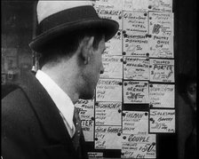 A Male Civilian Looking at a Board With Job Advertisements, 1932. Creator: British Pathe Ltd.