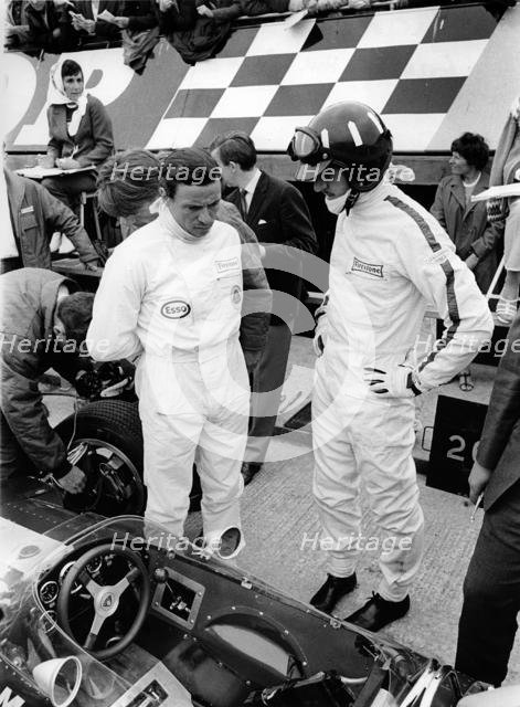 Jim Clark and Graham Hill in pits with Lotus 49 during 1967 British Grand Prix. Creator: Unknown.
