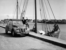 A Citroën 2CV on the quay at a harbour, c1957. Artist: Unknown
