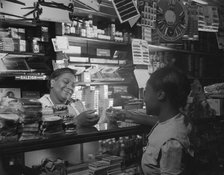 Clerk waiting on a customer in the store owned by Mr. J. Benjamin, Washington, D.C., 1942. Creator: Gordon Parks.
