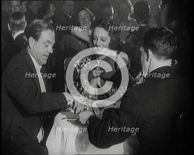 British Men and Women Sitting and Talking and Smoking at a Table in a Nightclub, 1922. Creator: British Pathe Ltd.