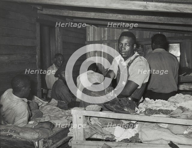 Negroes in bunkhouse in strawberry fields near Hammond, Louisiana; Note crude..., April 1939. Creators: Farm Security Administration, Russell Lee.