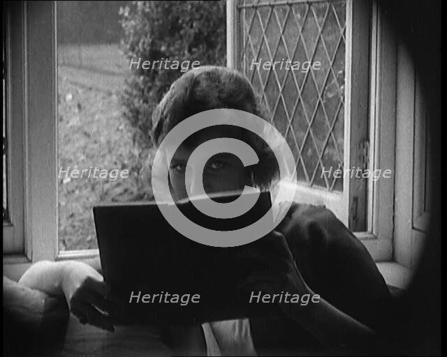 Evelyn Laye CBE, British Actress, Hiding Her Face Behind a Book, 1920. Creator: British Pathe Ltd.