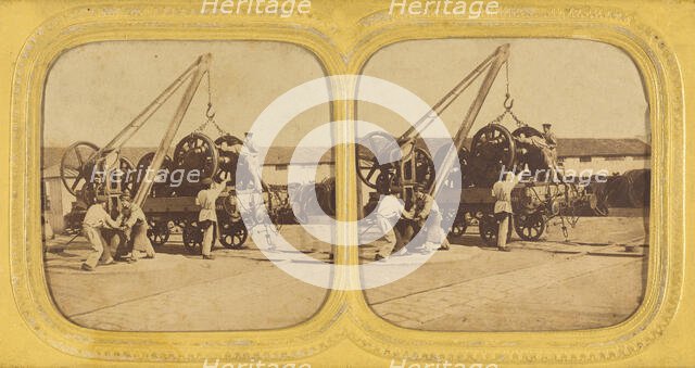 Men loading large iron wheels on platform, about 1865. Creator: Unknown.