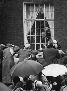 Sir Winston Churchill waving from his Hyde Park Gate window on the eve of his 90th birthday, 1964. Artist: Unknown