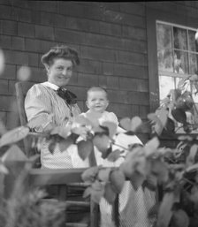Unidentified woman and baby, seated on porch, between 1911 and 1942. Creator: Arnold Genthe.