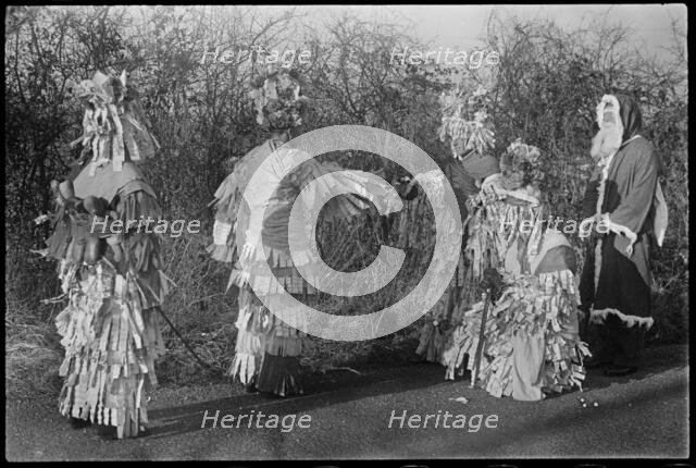 A group of people in costume performing in a Mummers' play, Andover, Test Valley, Hampshire, 1948. Creator: George R Long.
