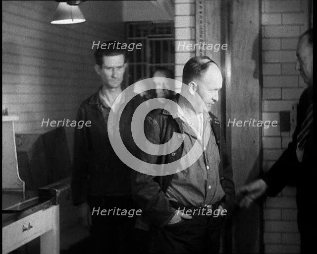 A group of Male Americans Civilians Wearing Prisoners Outfits Being Escorted Into a Room..., 1930. Creator: British Pathe Ltd.