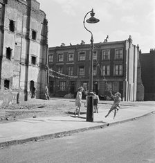 Children swinging on a lamppost, London, 1960-1965. Artist: John Gay