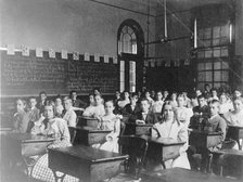 Girls and boys seated at desks in Washington, D.C. classroom, (1899?). Creator: Frances Benjamin Johnston.