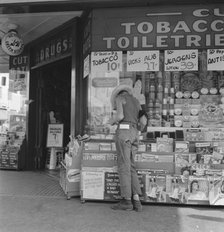 Half-grown farm boy on main drugstore corner in town, Medford, Oregon, 1939. Creator: Dorothea Lange.