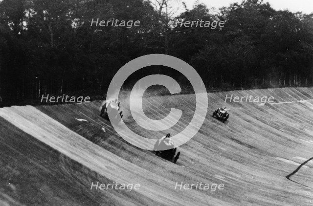 Louis Zborowski passing Humphrey Cook's Ballot by skidding above him, Brooklands. Artist: Unknown
