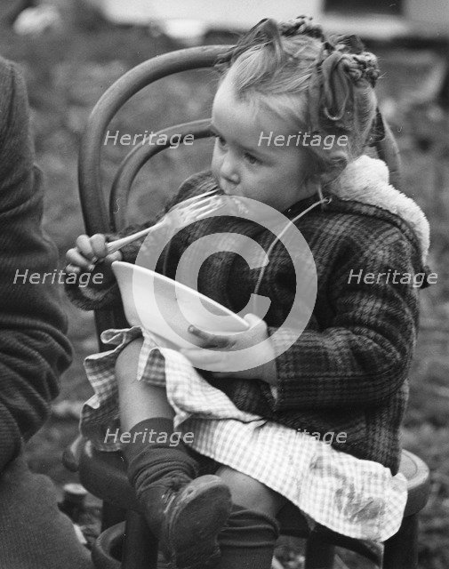 Gypsy girl eating, 1960s.