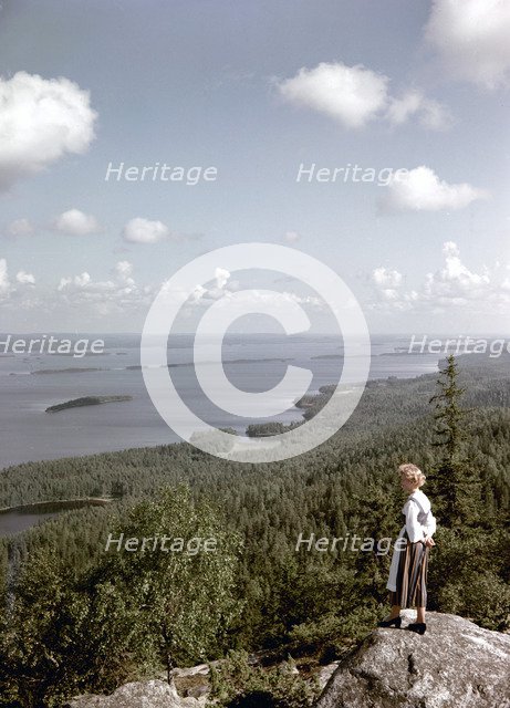 A young woman in traditional dresslooking out over Lake Pielinen, Koli district, Finland, 1960s. Artist: Göran Algård