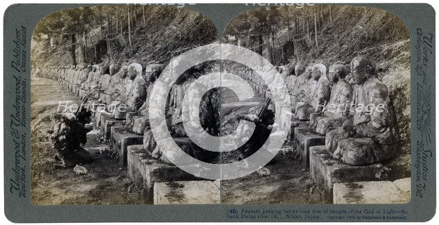 Peasant praying before a row of statues of the God of Light, Daiya river, Nikko, Japan, 1904.Artist: Underwood & Underwood
