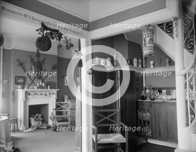 Hallway with liquor cabinet and living room decorated with mistletoe ball and Christm..., c1900-1915 Creator: Unknown.