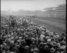 A Crowd of People Watching Horses Racing at Ascot Race Track, 1924. Creator: British Pathe Ltd.