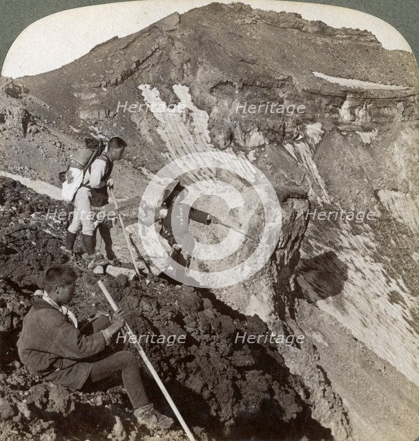 Peering from the lava encrusted rim down into Mount Fuji's (Fujiyama's) crater, Japan, 1904.Artist: Underwood & Underwood