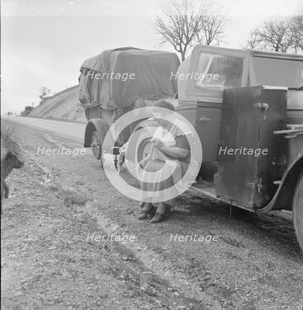 Migrant pea workers on the road, all their worldly possessions in car and trailer, California, 1936. Creator: Dorothea Lange.