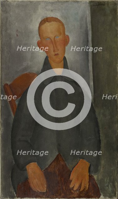 Seated boy with red hair and grey jacket.