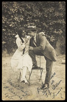 Two actors, one in drag, pose on garden furniture, 1918. Creator: Unknown.