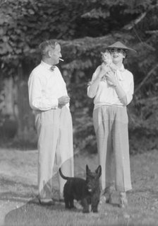 Leonard, Mr. and Mrs., with cat and dog, standing outdoors, between 1926 and 1938. Creator: Arnold Genthe.